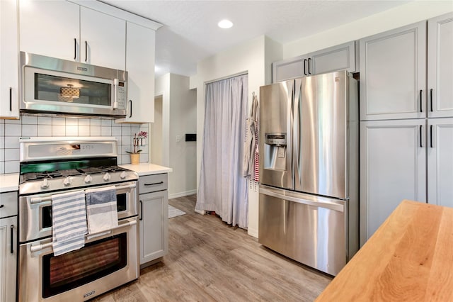 1346 Lilly Ct, Missoula, MT 59802 - kitchen with stainless steel appliances, gray cabinets, light wood finished floors, backsplash, and recessed lighting