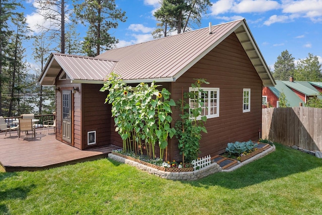 14980 Mt Highway 35, Bigfork, MT 59911 - view of property exterior with a deck, outdoor dining area, a metal roof, and an outbuilding