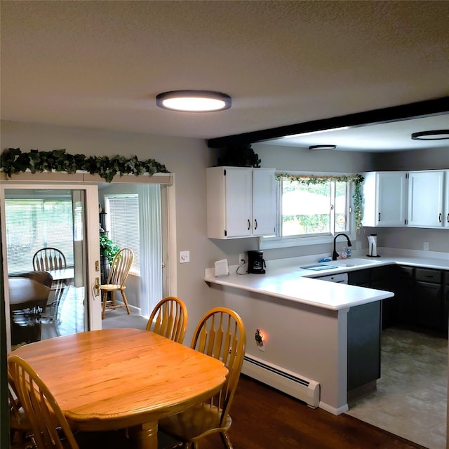4400 Sierra Dr, Missoula, MT 59804 - kitchen featuring baseboard heating, a peninsula, light countertops, white cabinets, and a textured ceiling