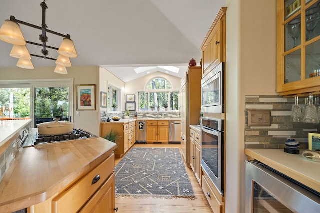 35AND33 Lakeside Ave, Lakeside, MT 59922 - kitchen with stainless steel appliances, lofted ceiling, wine cooler, a skylight, and glass insert cabinets