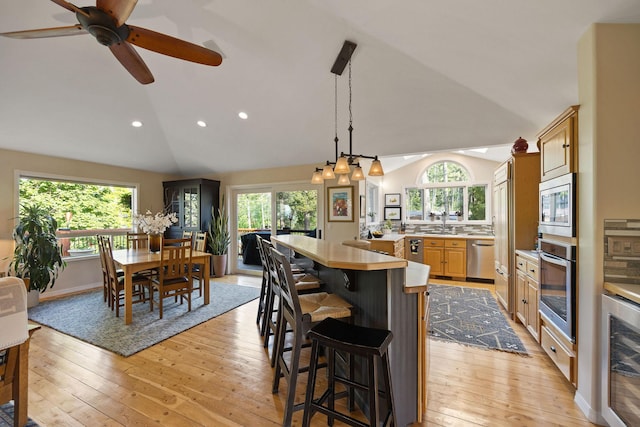 35AND33 Lakeside Ave, Lakeside, MT 59922 - kitchen with appliances with stainless steel finishes, vaulted ceiling, light wood finished floors, a breakfast bar, and recessed lighting