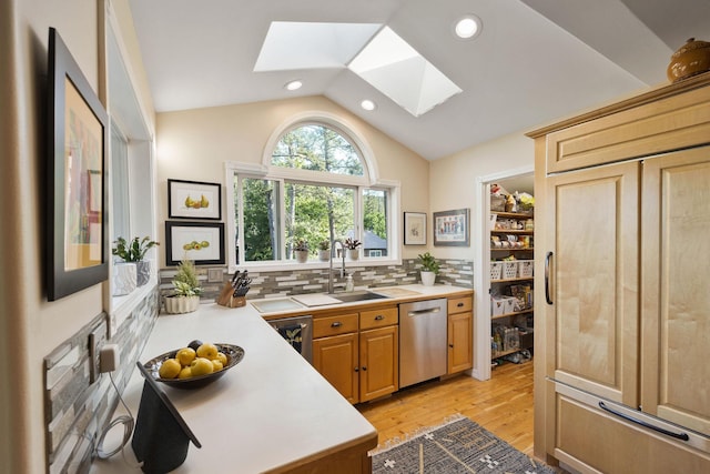 35AND33 Lakeside Ave, Lakeside, MT 59922 - kitchen with dishwasher, a skylight, light countertops, vaulted ceiling, and tasteful backsplash