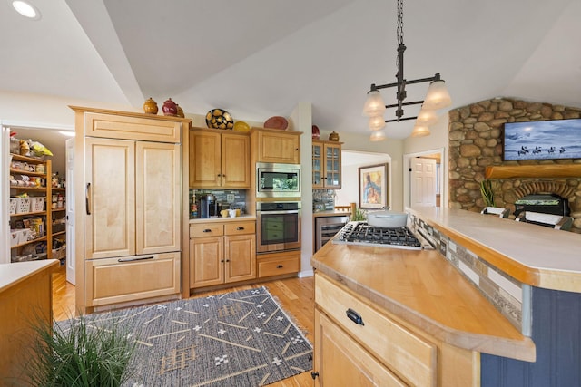 35AND33 Lakeside Ave, Lakeside, MT 59922 - kitchen with built in appliances, vaulted ceiling, beverage cooler, light brown cabinetry, and light wood-type flooring