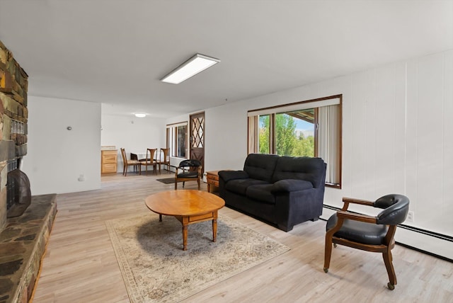 91 Denver Ave, Kalispell, MT 59901 - living room featuring light wood-style flooring, a baseboard radiator, and a stone fireplace