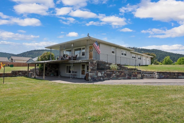 91 Denver Ave, Kalispell, MT 59901 - back of house with a mountain view, a patio, and a lawn