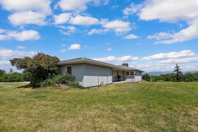91 Denver Ave, Kalispell, MT 59901 - rear view of house with a lawn and a chimney