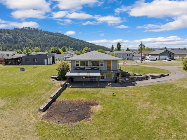 91 Denver Ave, Kalispell, MT 59901 - back of house with a lawn, a residential view, a deck with mountain view, driveway, and a shingled roof