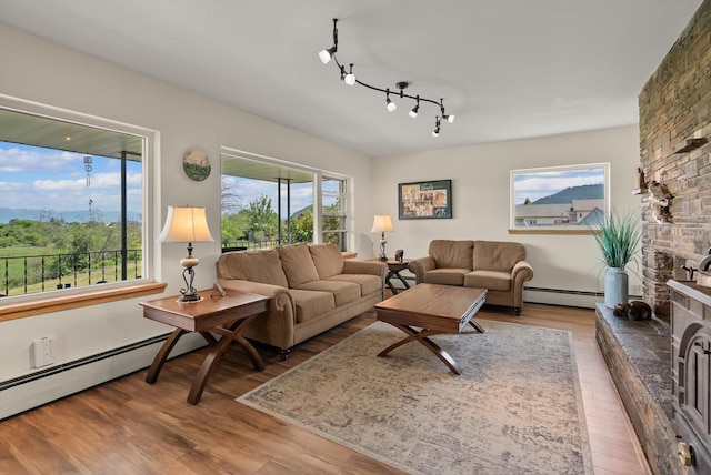 91 Denver Ave, Kalispell, MT 59901 - living room featuring wood finished floors, baseboard heating, and a large fireplace