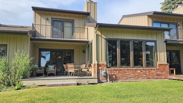 122 Fairway Blvd, Kalispell, MT 59901 - rear view of property featuring a balcony, a chimney, a yard, and brick siding
