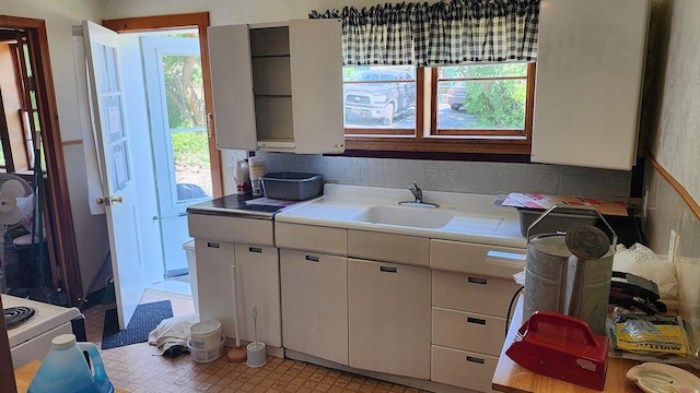 21439 Rollins Lakeshore Dr, Rollins, MT 59931 - kitchen featuring light countertops, white cabinets, and backsplash