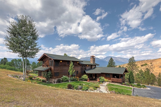 349 Harlan Creek Rd, Hamilton, MT 59840 - view of front of home with a front lawn, a chimney, a mountain view, and a porch