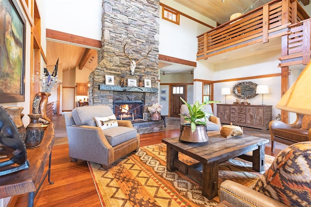 349 Harlan Creek Rd, Hamilton, MT 59840 - living area featuring high vaulted ceiling, wood finished floors, a stone fireplace, and a wooden ceiling with exposed beams