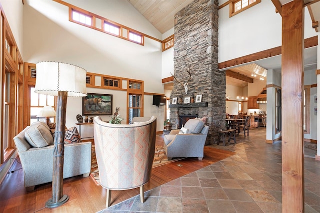 349 Harlan Creek Rd, Hamilton, MT 59840 - living room with high vaulted ceiling, stone tile floors, decorative columns, a fireplace, and wood ceiling