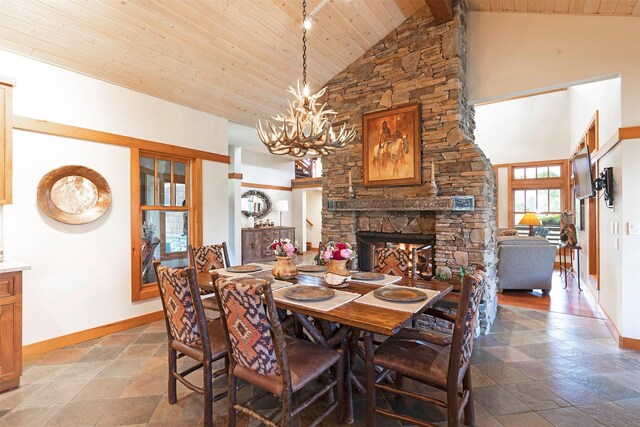 349 Harlan Creek Rd, Hamilton, MT 59840 - dining space with a wooden ceiling with exposed beams, a chandelier, high vaulted ceiling, a stone fireplace, and light stone finish flooring