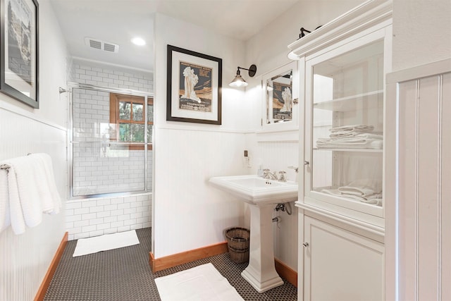 349 Harlan Creek Rd, Hamilton, MT 59840 - bathroom with tiled shower, wainscoting, and tile patterned flooring