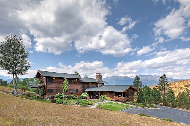 349 Harlan Creek Rd, Hamilton, MT 59840 - back of property with a mountain view, a chimney, and a lawn