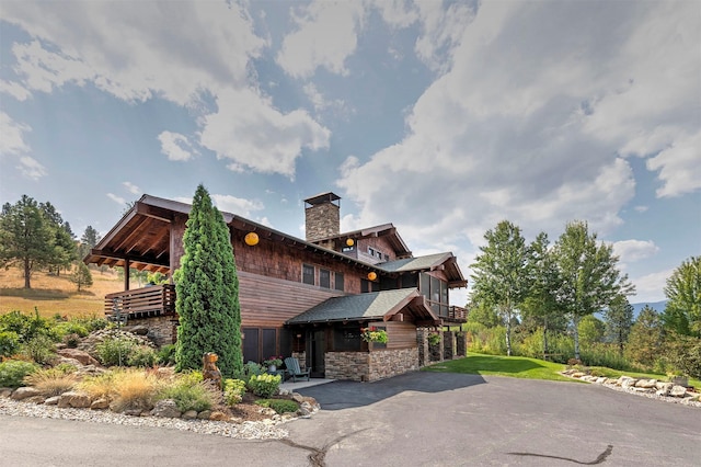 349 Harlan Creek Rd, Hamilton, MT 59840 - view of property exterior with stone siding, a chimney, and asphalt driveway