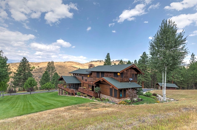 349 Harlan Creek Rd, Hamilton, MT 59840 - rear view of house with a deck with mountain view, a chimney, a yard, and stone siding