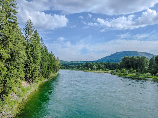 716 Kootenai River Rd, Troy, MT 59935 - water view with a heavily wooded area and a mountainous background