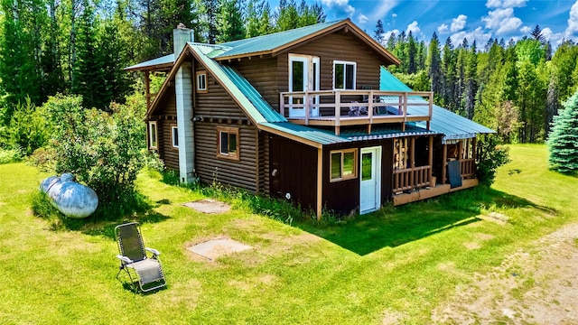 17 Twenty Peak Gulch Ln, Trout Creek, MT 59874 - back of house with a chimney, a lawn, a metal roof, a deck, and a view of trees