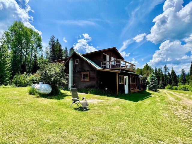 17 Twenty Peak Gulch Ln, Trout Creek, MT 59874 - rear view of house with a chimney, a yard, a wooden deck, and log veneer siding