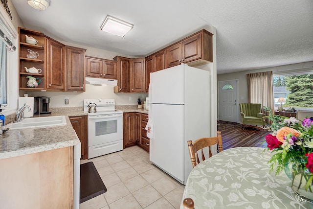 3875 Kiki Dr Unit 3875, Helena, MT 59602 - kitchen featuring white appliances, under cabinet range hood, light countertops, open shelves, and brown cabinetry