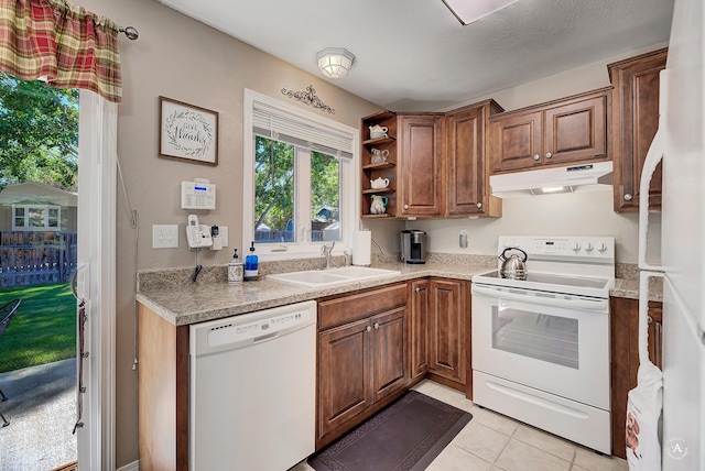 3875 Kiki Dr Unit 3875, Helena, MT 59602 - kitchen featuring white appliances, under cabinet range hood, brown cabinetry, and light tile patterned floors