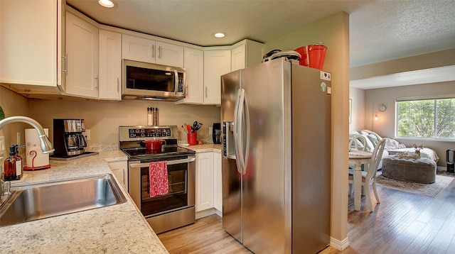 5530 Creekstone Dr Unit 6, Missoula, MT 59808 - kitchen featuring appliances with stainless steel finishes, light wood-style flooring, white cabinetry, light countertops, and recessed lighting
