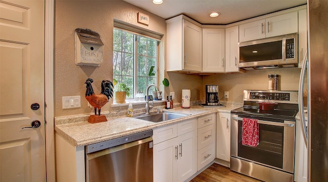 5530 Creekstone Dr Unit 6, Missoula, MT 59808 - kitchen with stainless steel appliances, white cabinets, recessed lighting, wood finished floors, and a textured wall