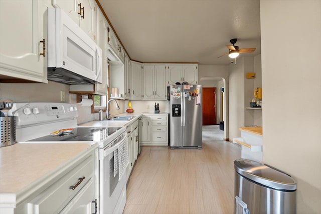321 6th Ave W, Kalispell, MT 59901 - kitchen featuring white appliances, a ceiling fan, light countertops, arched walkways, and white cabinets