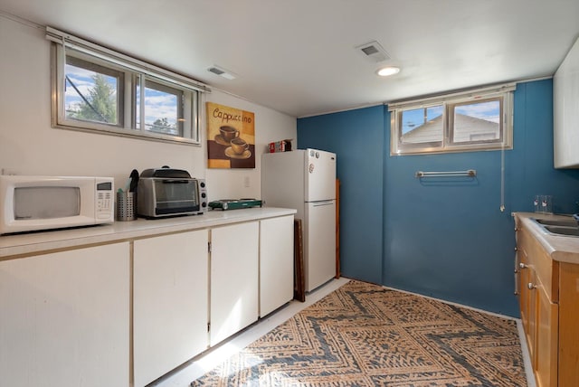 321 6th Ave W, Kalispell, MT 59901 - kitchen with white appliances, light countertops, and healthy amount of natural light