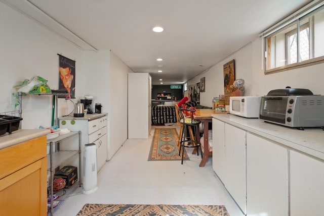 321 6th Ave W, Kalispell, MT 59901 - kitchen featuring white microwave, light countertops, recessed lighting, finished concrete floors, and white cabinetry