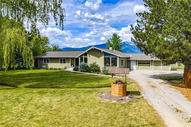 4291 Williams Ln, Stevensville, MT 59870 - ranch-style house with driveway, a garage, a chimney, a mountain view, and a front yard