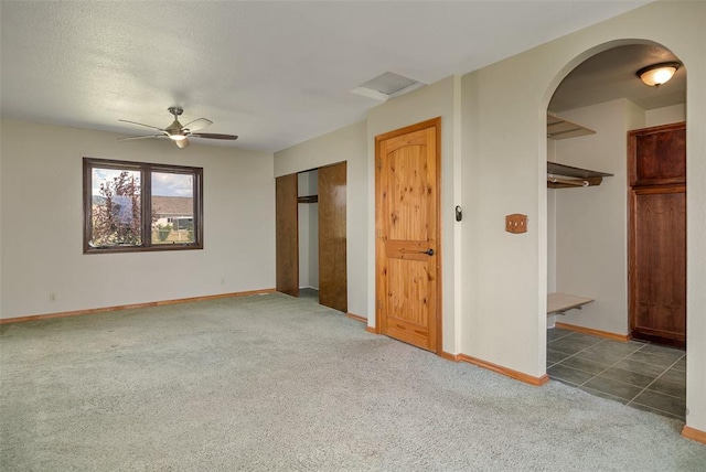 8340 Green Meadow Dr, Helena, MT 59602 - unfurnished living room featuring carpet floors, arched walkways, and a ceiling fan