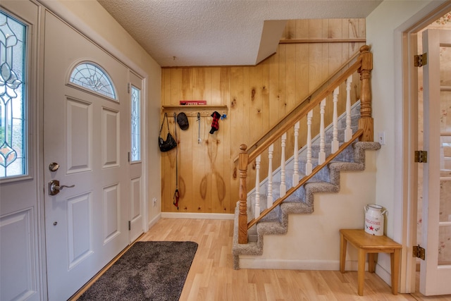 238 Hillcrest Dr, Hamilton, MT 59840 - foyer entrance featuring stairway, wood finished floors, a textured ceiling, healthy amount of natural light, and wooden walls