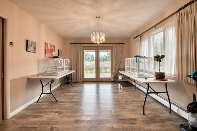 238 Hillcrest Dr, Hamilton, MT 59840 - living area with a chandelier, wood finished floors, a baseboard heating unit, and a textured ceiling