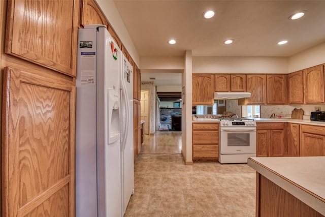 238 Hillcrest Dr, Hamilton, MT 59840 - kitchen featuring white appliances, under cabinet range hood, light countertops, recessed lighting, and brown cabinetry