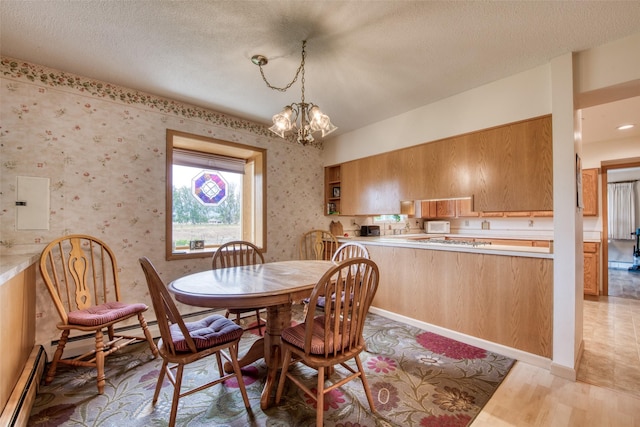 238 Hillcrest Dr, Hamilton, MT 59840 - dining space featuring baseboard heating, a chandelier, a textured ceiling, light wood-style flooring, and wallpapered walls