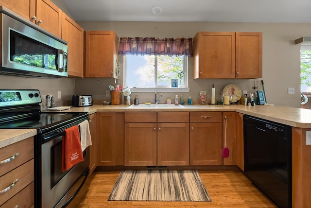 36 W Northview Loop, Kalispell, MT 59901 - kitchen with appliances with stainless steel finishes, a peninsula, light wood finished floors, light countertops, and brown cabinets