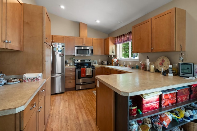 36 W Northview Loop, Kalispell, MT 59901 - kitchen with appliances with stainless steel finishes, light countertops, lofted ceiling, a peninsula, and light wood finished floors