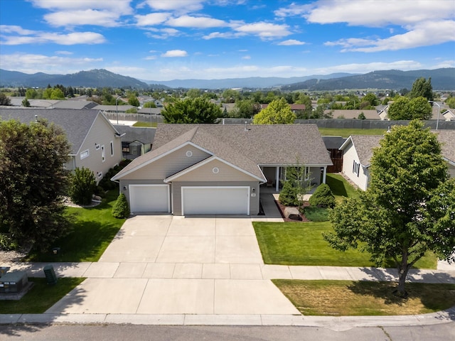 36 W Northview Loop, Kalispell, MT 59901 - view of front of house featuring an attached garage, a mountain view, driveway, a front lawn, and a residential view