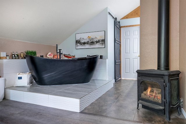2075 Lion Mountain Loop Rd, Whitefish, MT 59937 - bathroom with lofted ceiling and a wood stove