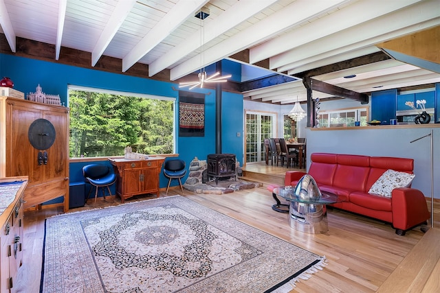 2075 Lion Mountain Loop Rd, Whitefish, MT 59937 - living area featuring a wood stove, wood finished floors, and a wooden ceiling with exposed beams