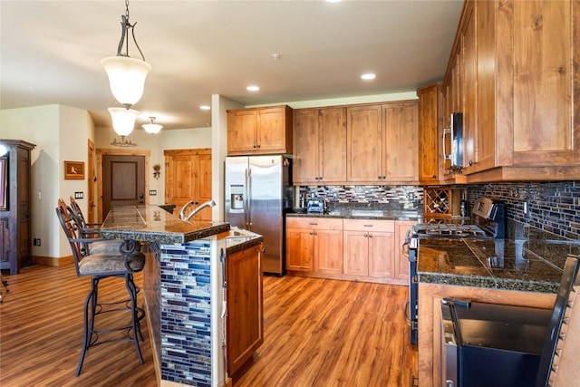 7175 US Highway 93 S Unit 4-102, Lakeside, MT 59922 - kitchen featuring appliances with stainless steel finishes, tile counters, light wood-type flooring, a kitchen bar, and recessed lighting