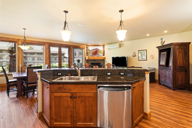 7175 US Highway 93 S Unit 4-102, Lakeside, MT 59922 - kitchen with stainless steel dishwasher, tile countertops, a wall mounted AC, dark wood finished floors, and open floor plan