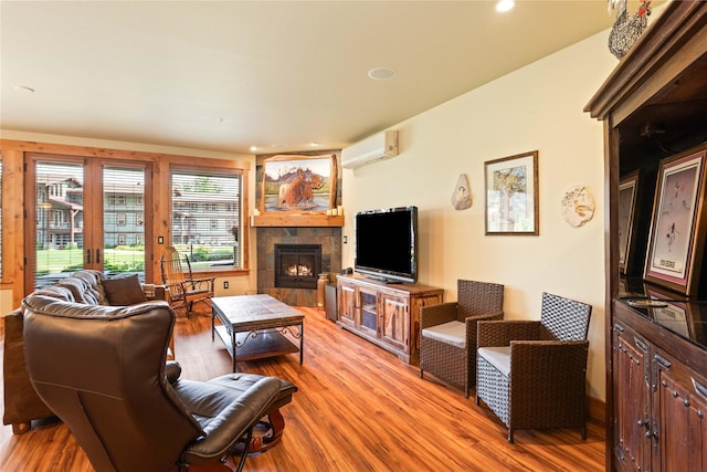 7175 US Highway 93 S Unit 4-102, Lakeside, MT 59922 - living room featuring light wood-style flooring, a fireplace, a wall mounted air conditioner, and recessed lighting
