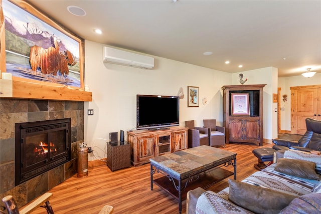 7175 US Highway 93 S Unit 4-102, Lakeside, MT 59922 - living area featuring an AC wall unit, wood finished floors, a tile fireplace, and recessed lighting