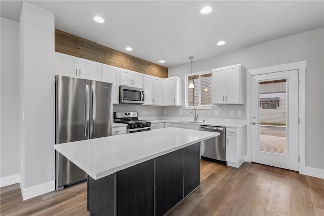 534 Colorado Ave, Whitefish, MT 59937 - kitchen with appliances with stainless steel finishes, white cabinetry, pendant lighting, light countertops, and light wood-style flooring