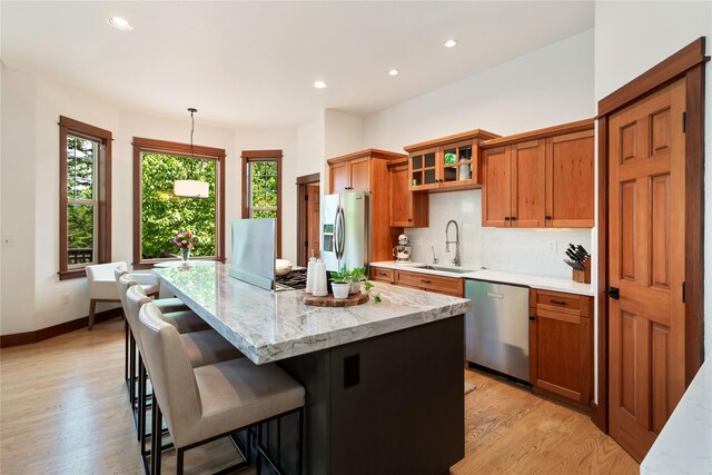255 Windsor Ct, Bigfork, MT 59911 - kitchen featuring appliances with stainless steel finishes, brown cabinets, recessed lighting, a center island, and light wood-style floors