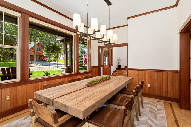 255 Windsor Ct, Bigfork, MT 59911 - dining room with wood walls, a wainscoted wall, a chandelier, crown molding, and light wood finished floors
